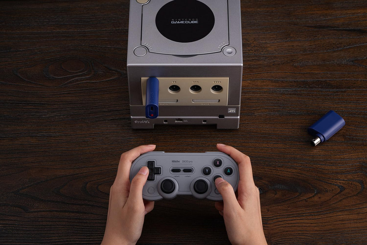 8BitDo receiver next to coin illustrating compact size and easy storage benefit