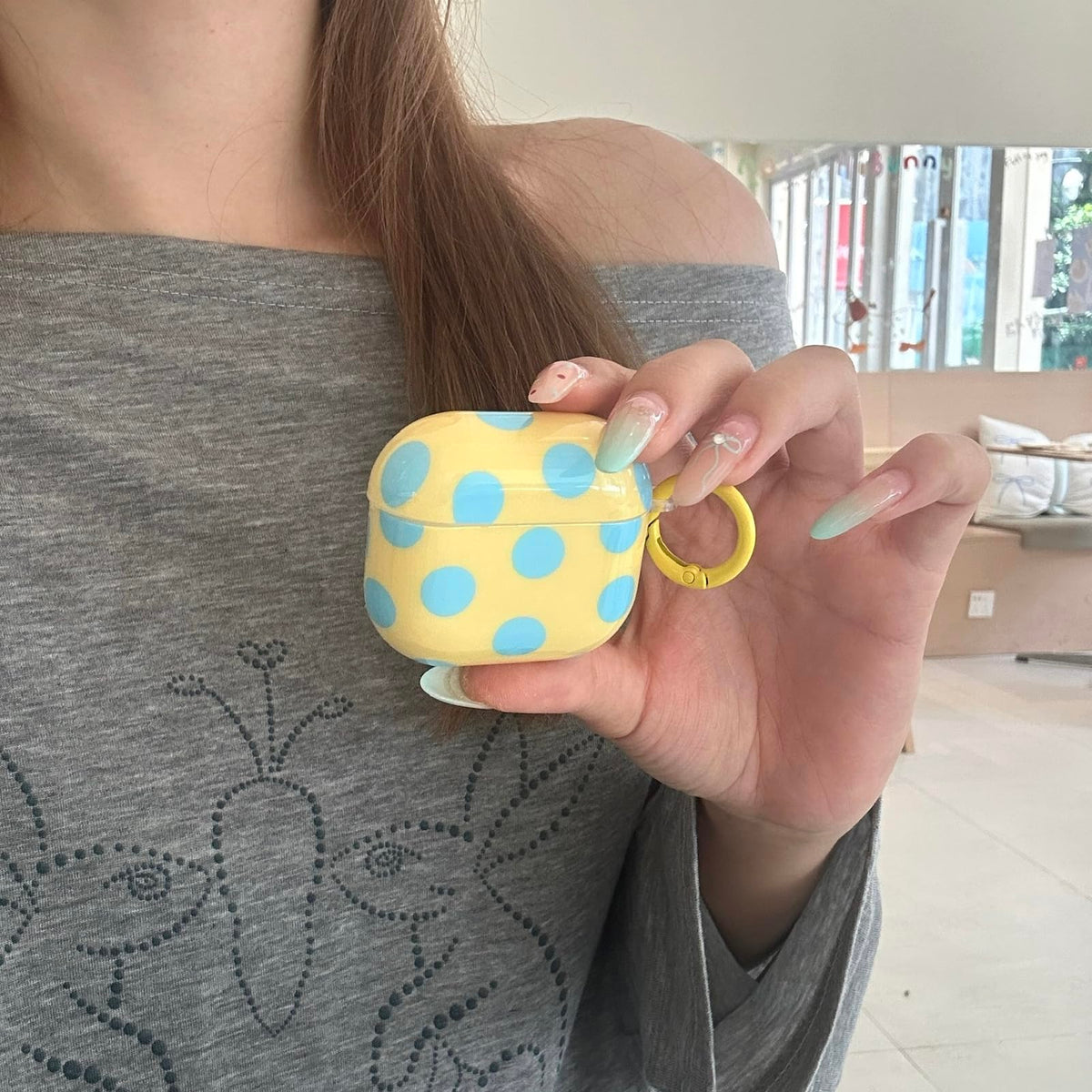 Aaknhen polka-dot AirPods 4 case side view shows lightweight protection for daily carry.