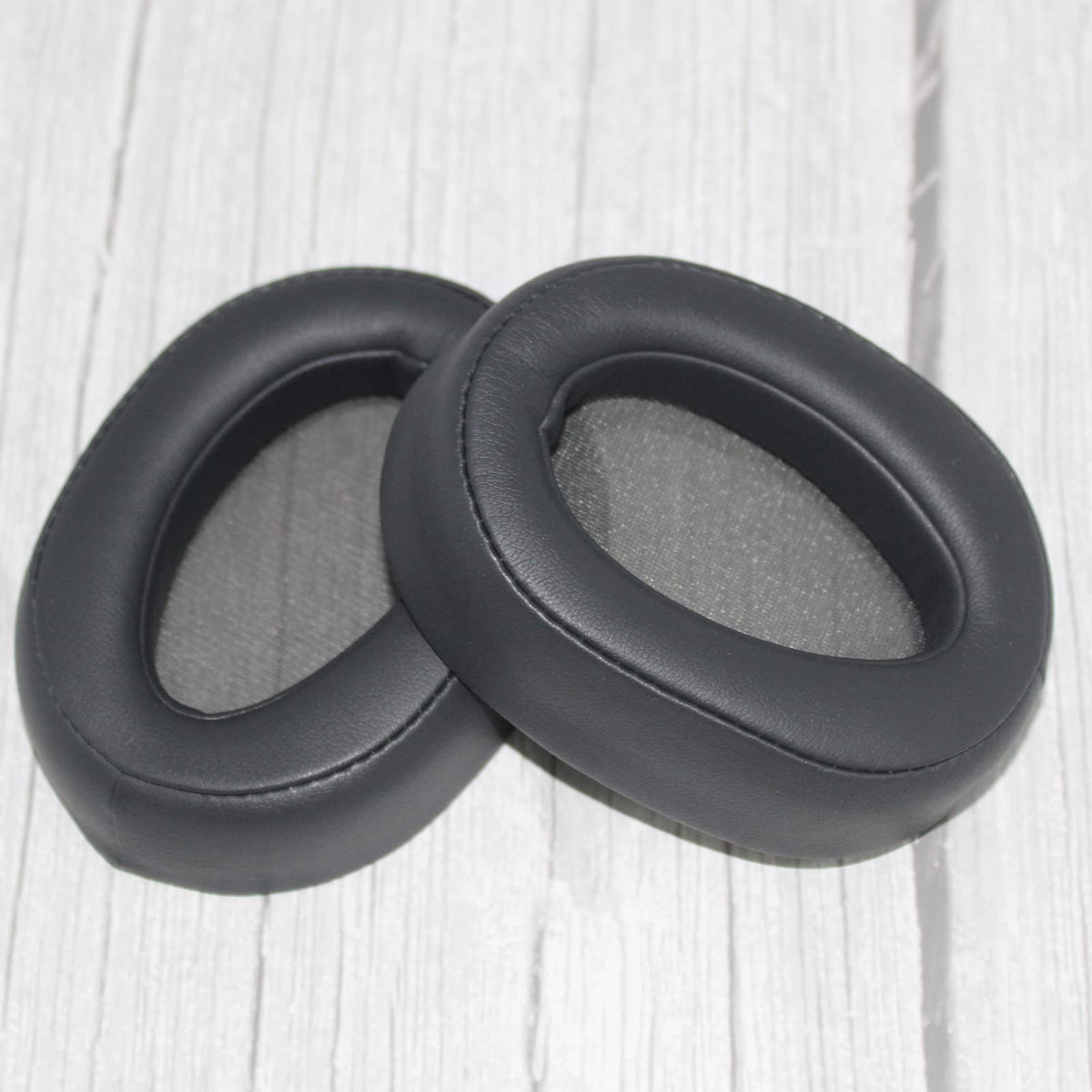 Adhiper ear pad next to coin indicates compact size and accurate fit