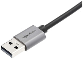 Amazon Basics USB 3.0 aluminum Ethernet adapter on laptop, portable for travel.