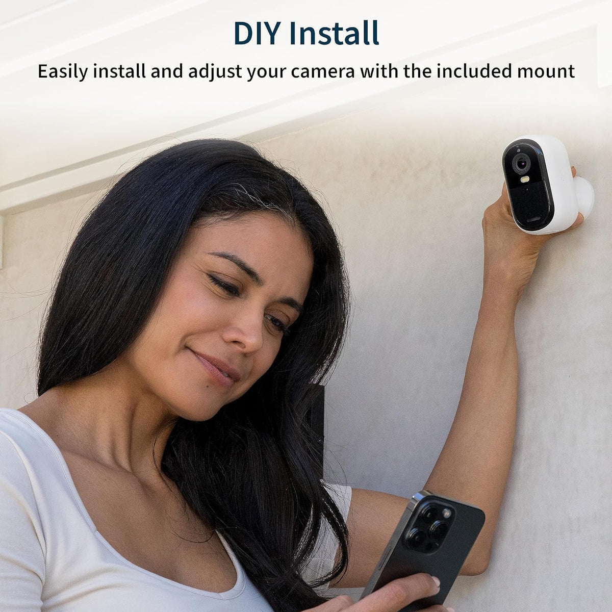 Arlo Essential next to a smartphone for scale showing compact size and easy installation