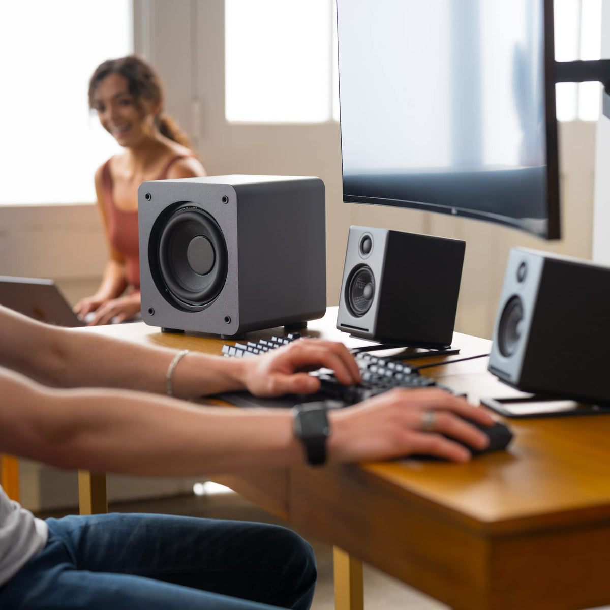 Audioengine S6 slim subwoofer shown in a modern living room.