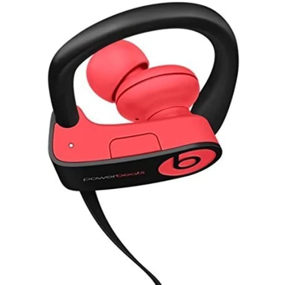 Beats Powerbeats3 Siren Red beside smartphone to show compact, travel‑ready scale