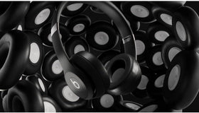 Beats Solo 4 matte black on-ear headphones during travel imply portability.