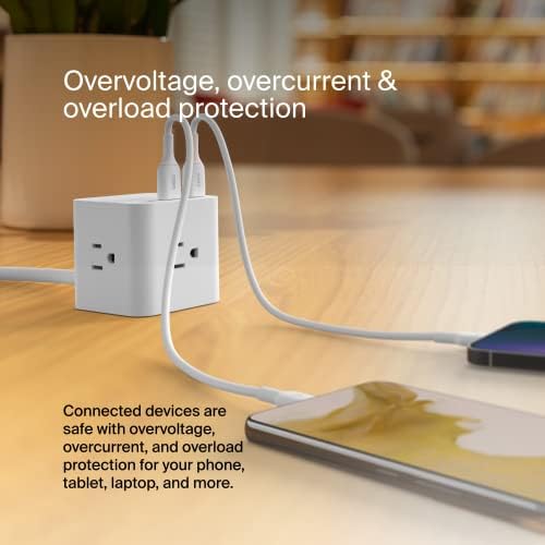 Belkin Power Cube on a clean desk powering phone, tablet, and laptop