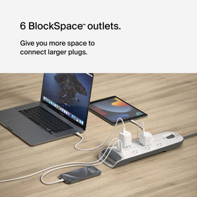 Belkin power strip on a home office desk powering multiple devices benefit