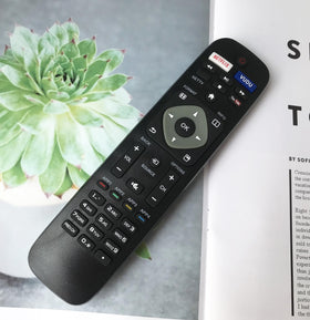 BOMAZ remote next to hand for size comparison illustrating slim ergonomic fit