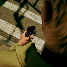 Bose QuietComfort Earbuds worn during commute with active noise cancellation.
