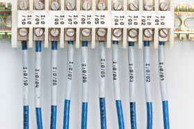 Brady tape roll beside ruler showing 0.375 inch width and length clarity