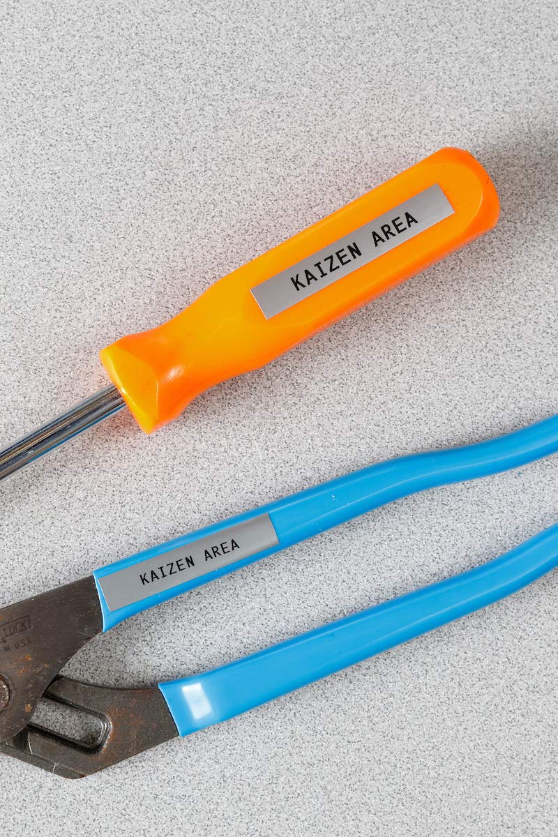 Brady label roll next to ruler showing 0.5 inch width and easy scale verification