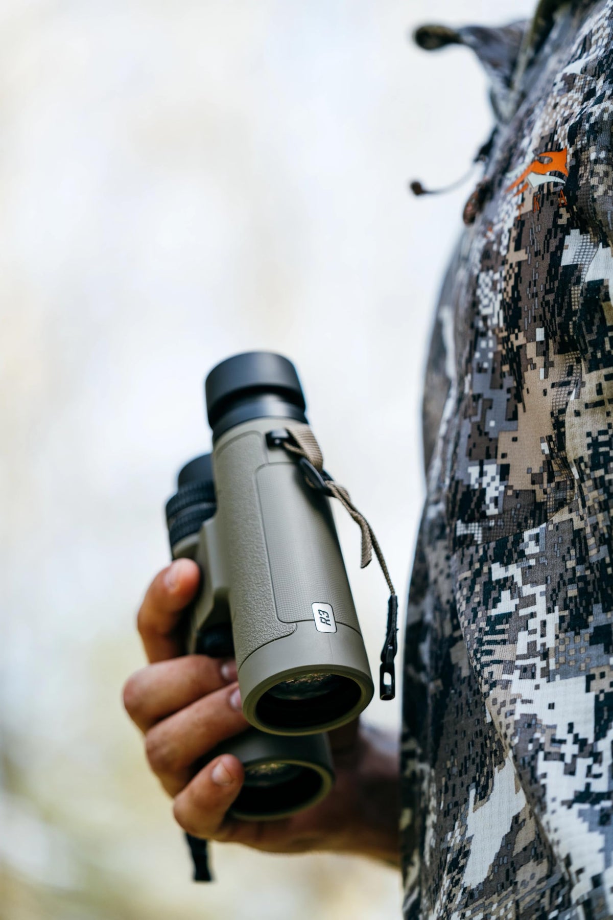 Bushnell R3 8x42 binoculars harness strap demonstrates hands-free wildlife observation.