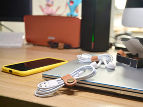 CAILLU cable management strap organizes chargers at desk and reduces clutter.