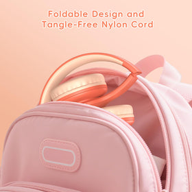 Candy Bila headphones beside a toy to show child-sized scale and comfortable fit