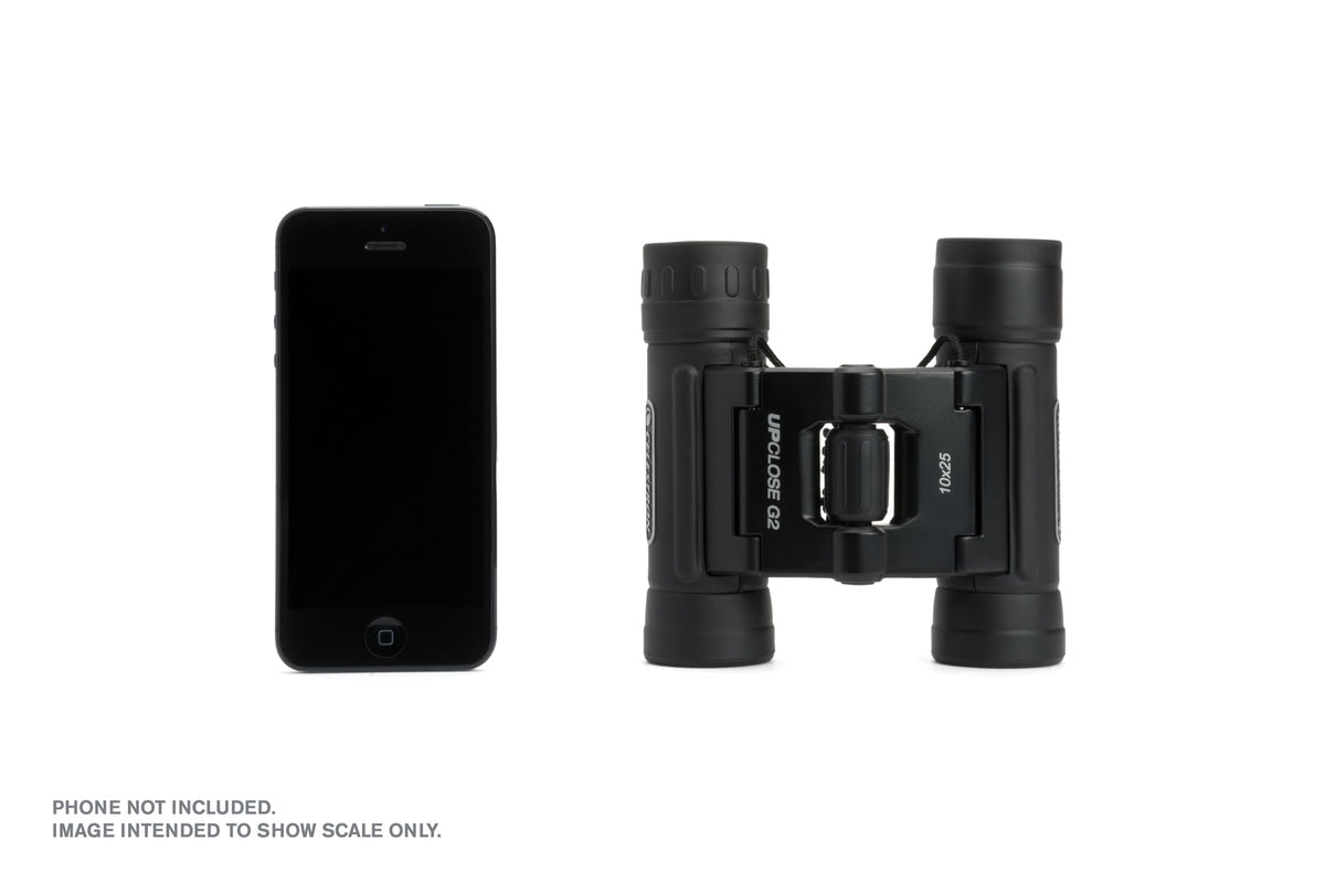 Celestron next to smartphone showing compact size and easy pocketing