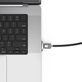 Compulocks adapter mounted beside MacBook trackpad showing secure use
