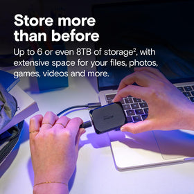 Crucial X10 4TB docked with computer emphasizes ultra-fast 2100 MB/s transfer speed.