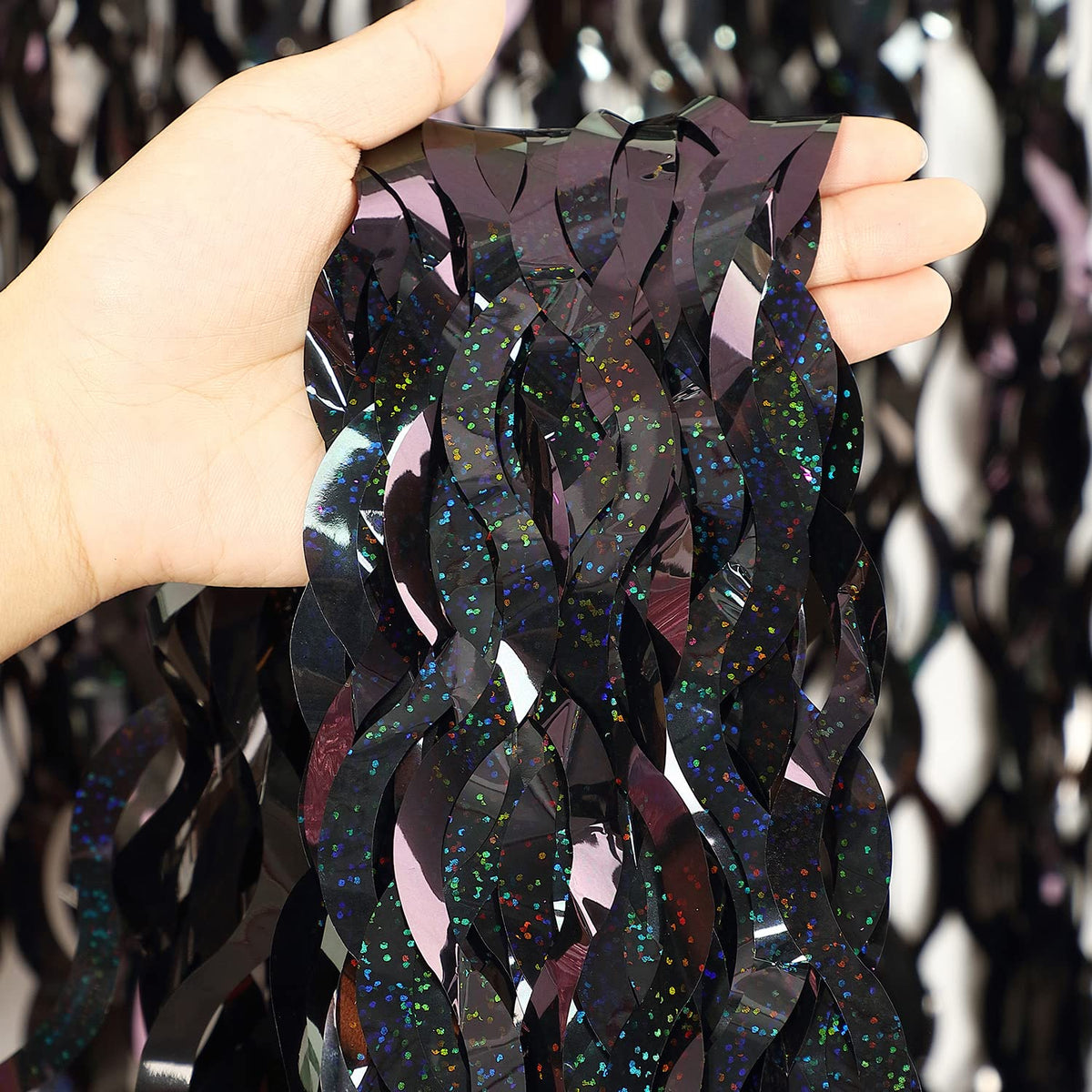 CYLMFC black foil curtain closeup highlights shiny metallic texture for festive decor.