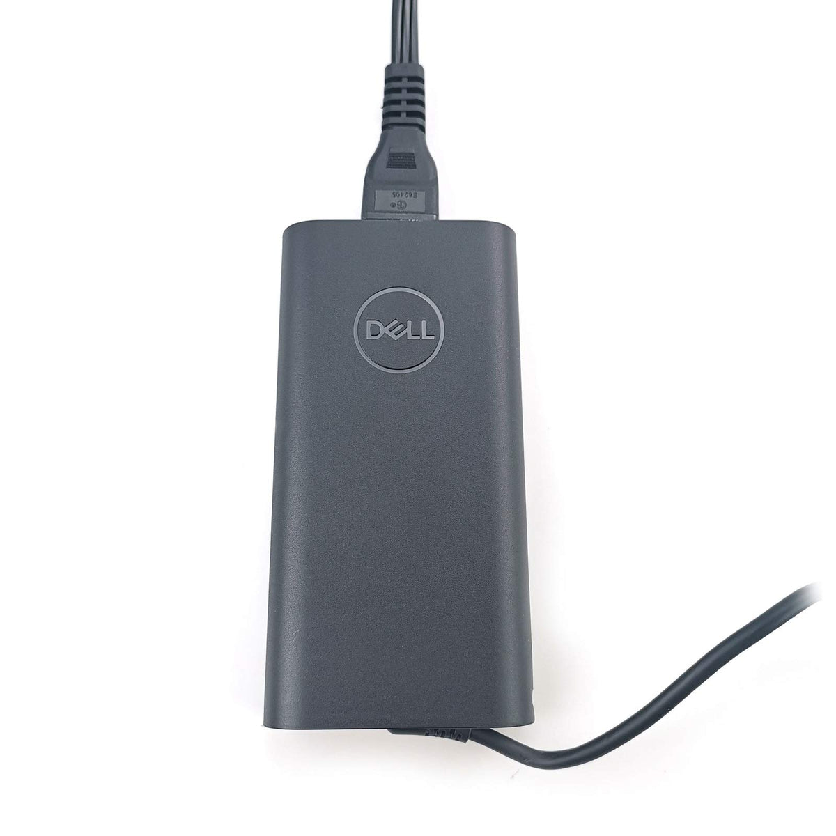 Dell adapter next to laptop for scale showing portable, travel-friendly size
