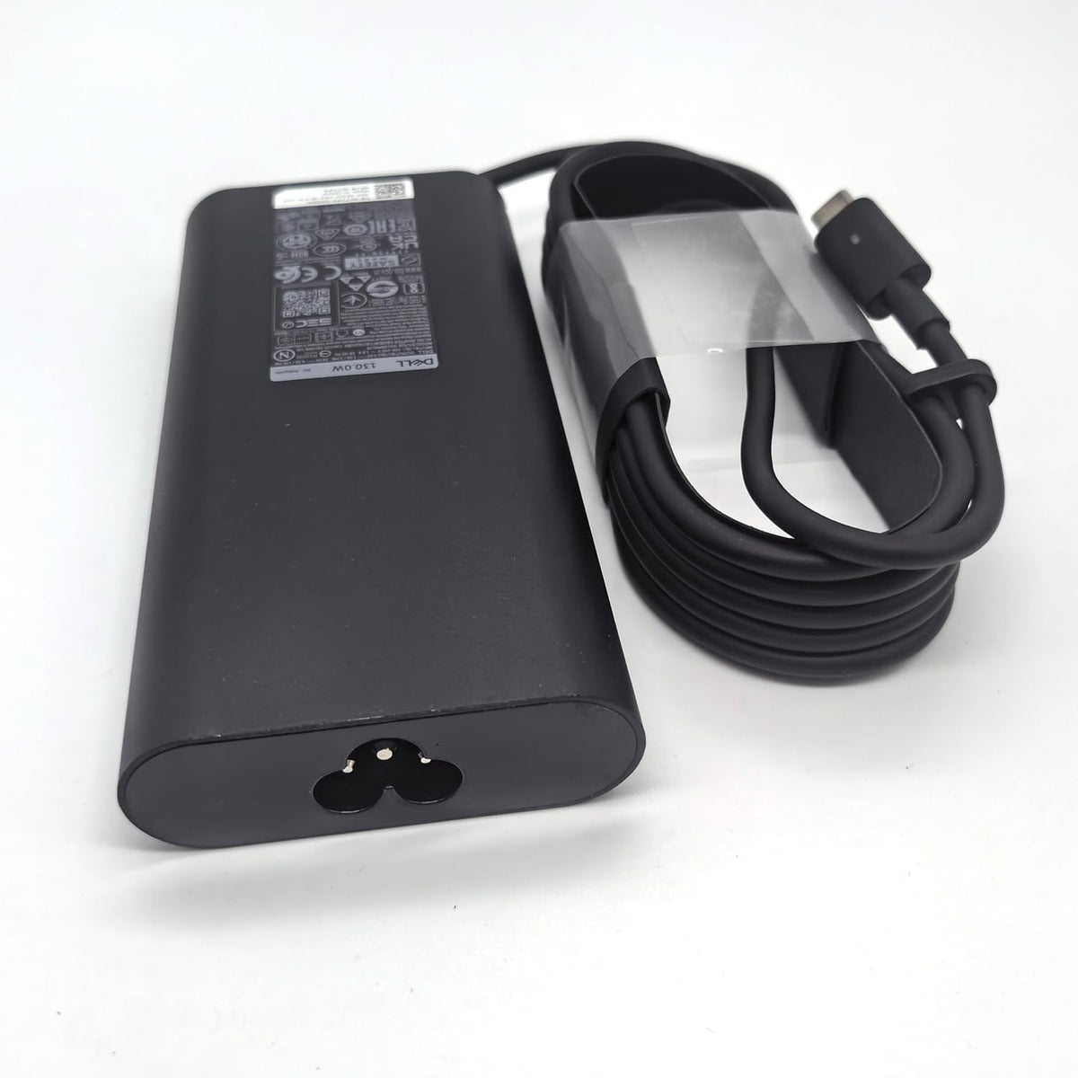 Dell charger next to ruler showing compact size and easy storage