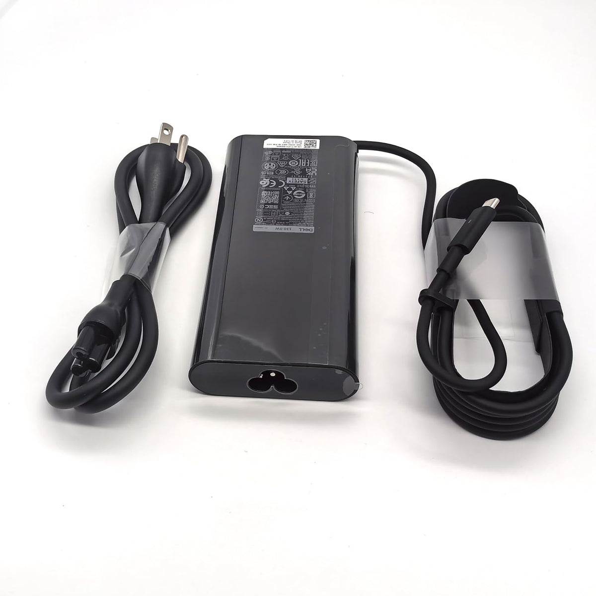 Dell adapter scale comparison in hand illustrating compact portability