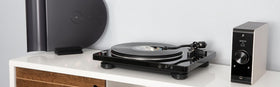 Denon DP-450USB tonearm closeup shows curved tracking for gentle record handling.