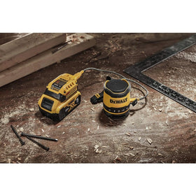 DEWALT DCR008 next to a hand for size comparison and portability benefit