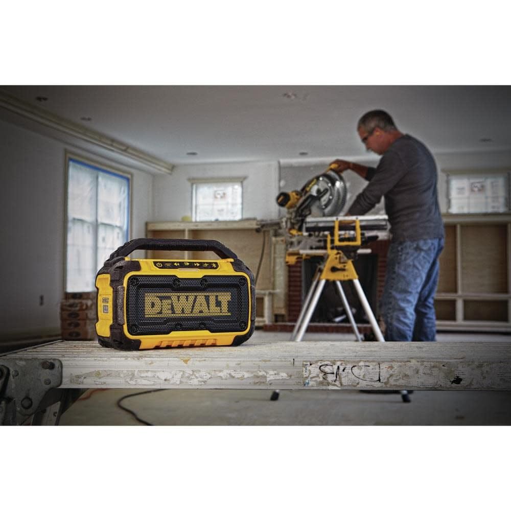 DEWALT DCR010 on jobsite with batteries demonstrates flexible power options.