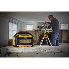 DEWALT DCR010 on jobsite with batteries demonstrates flexible power options.