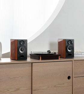 Edifier R1380T next to laptop showing compact scale for small spaces