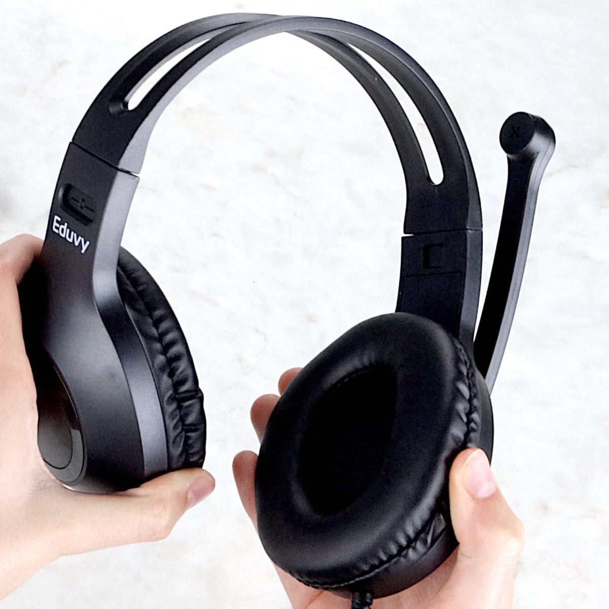 Eduvy headset beside textbook showing compact size and classroom scale