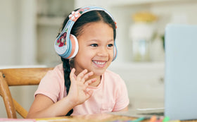 child wearing eKids Moana headphones watching a tablet for school or entertainment