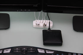 ENVISIONED compact desk cord holder shows a 7-slot layout for daily setup.