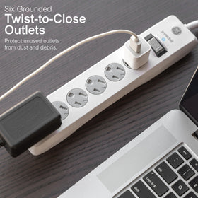 GE flat plug tucked behind sofa saves space and keeps adjacent outlet accessible
