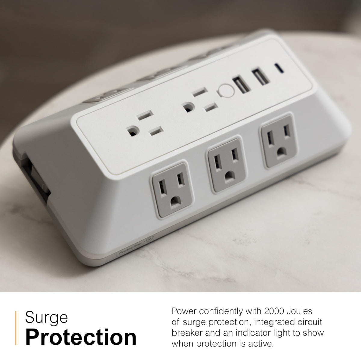 GE surge tap in use on desk charging phone laptop and lamp for convenience