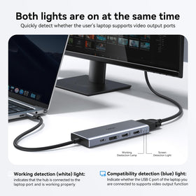 HODO dock next to laptop for scale showing compact size and travel-friendly footprint