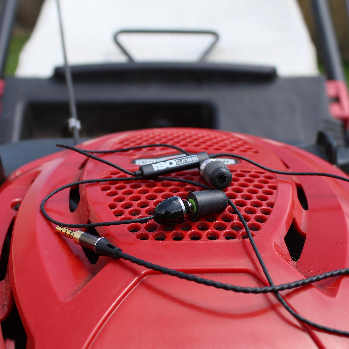ISOtunes earbuds beside a coin showing compact scale and portable convenience