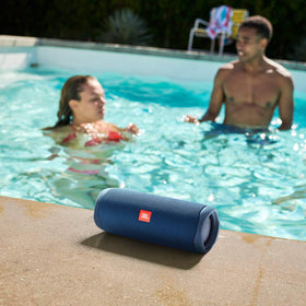 JBL Flip 5 Ocean Blue side view, rugged portable speaker for outdoor use.