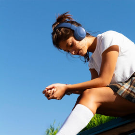 JBL Tune 520BT folded beside a smartphone to show compact size and travel ease
