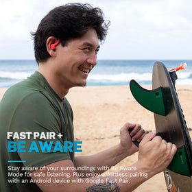JLab Go Sport+ coral earbuds beside scale showing compact size