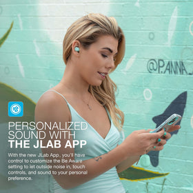 JLab earbuds in hand for scale illustrating how small and pocketable they are