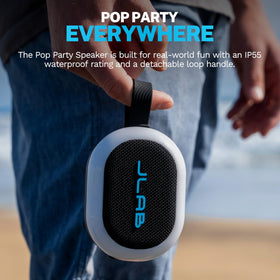 JLab Pop Party on a pool towel with splashes, demonstrates IP55 water resistance benefit