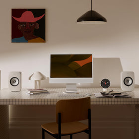 KEF LSX II LT stone white desk setup with TV, showcasing versatile placement