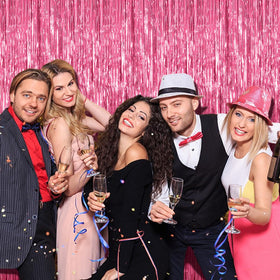 K.E.J. pink metallic tinsel curtain creates shimmering photo booth backdrop.