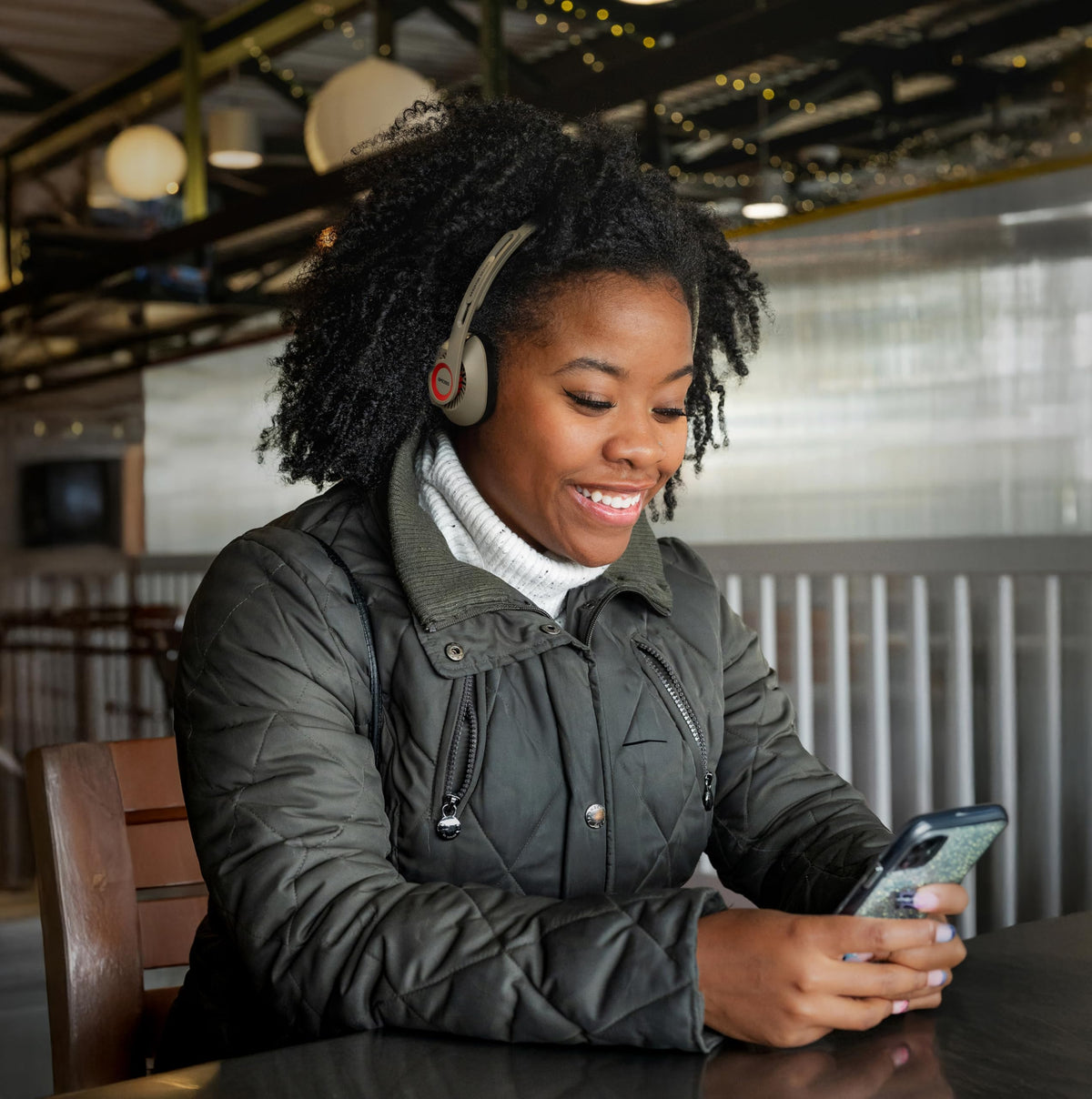 Koss KPH30 next to a smartphone to show scale and portable convenience