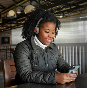 Koss KPH30 next to a smartphone to show scale and portable convenience