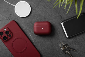 Latercase crimson on desk with earbuds showing everyday carry style benefit