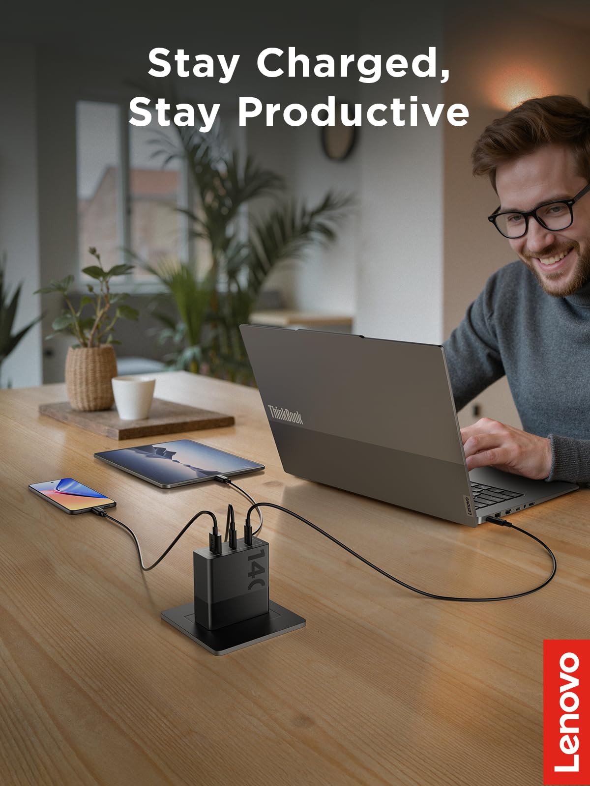Lenovo 140W USB-C charger on desk with laptop showing multi-device compatibility.