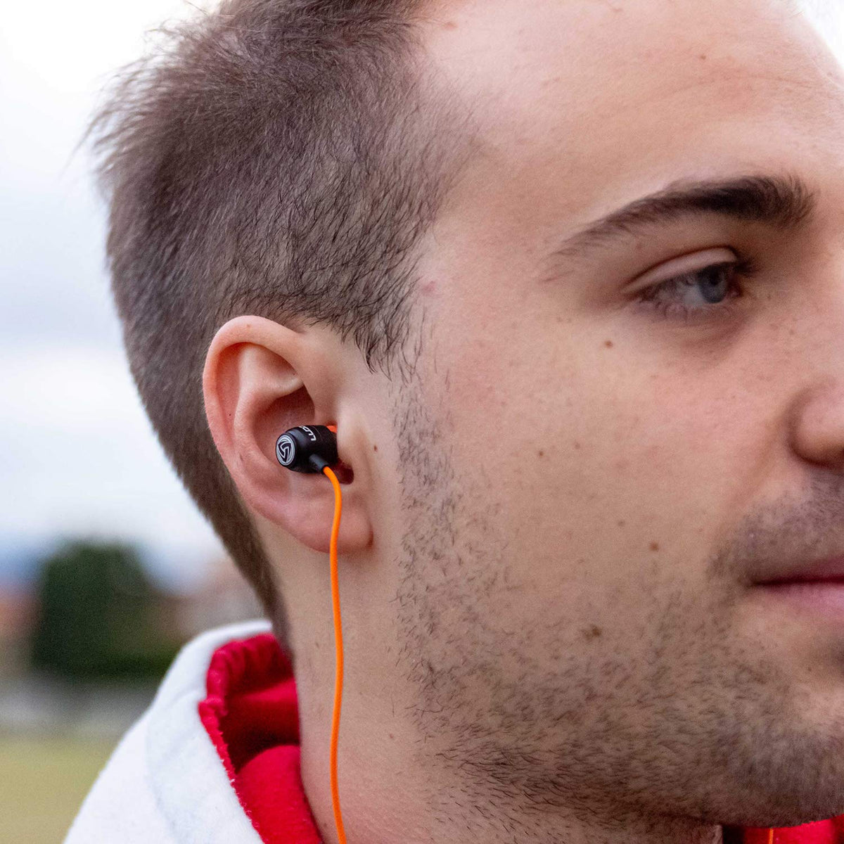 Memory foam tips on LUDOS Clamor orange earbuds for secure, comfortable fit