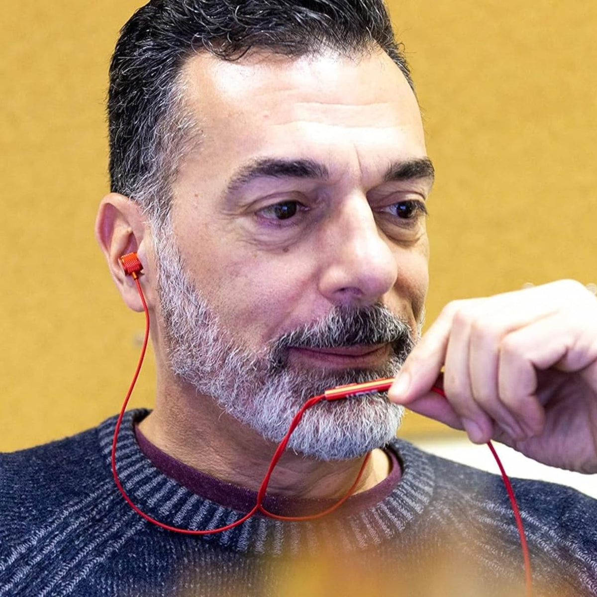 LUDOS Ultra earbud plugged into iPhone showing use, delivering low‑latency wired audio