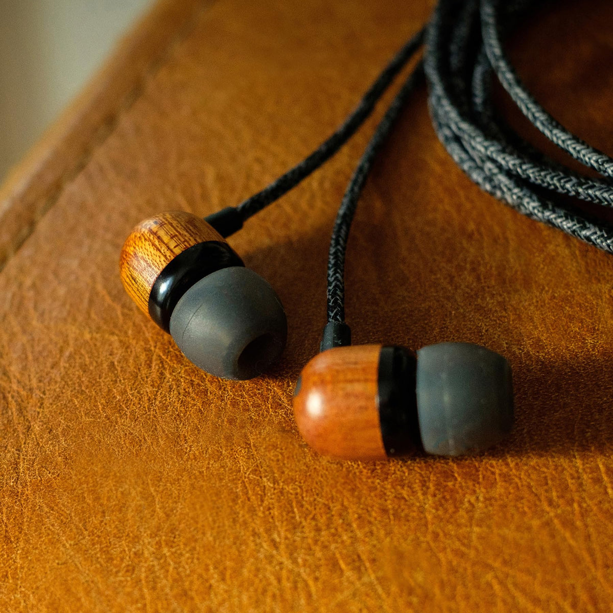 Materials close-up highlighting aluminium, FSC wood, and REWIND fabric on Marley earbuds.